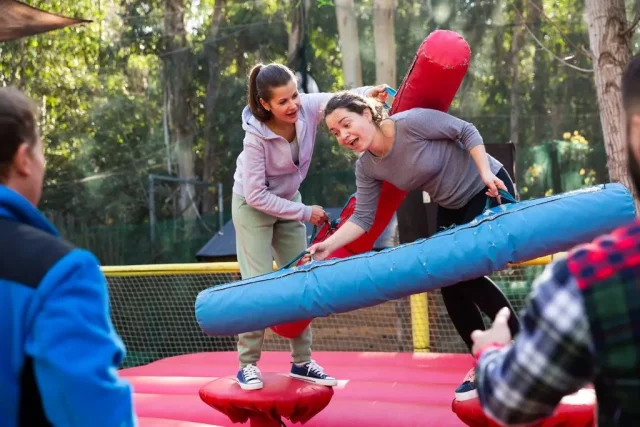 humor amarillo duelo con bastones hinchables sobre plataforma hinchable al aire libre